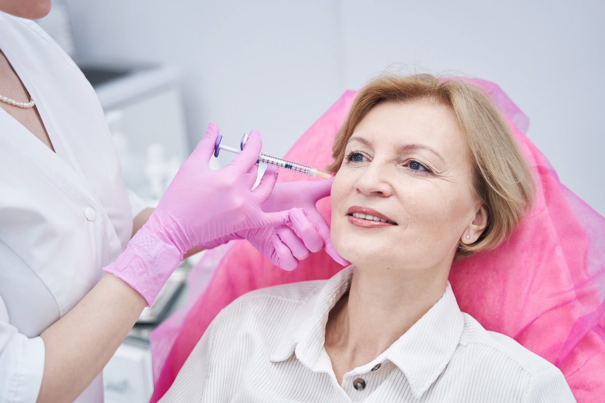 Older woman receiving a cosmetic injectable treatment near the cheek - SoBro Dental